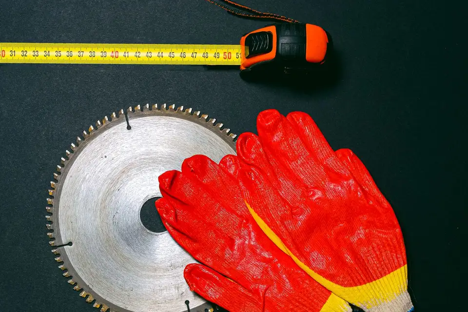 Construction tools and work gloves laid out on a work surface